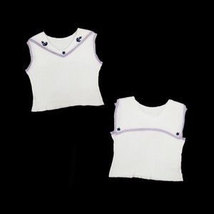 May include: White sleeveless top with a purple trim and blue embroidered stars and anchors.
