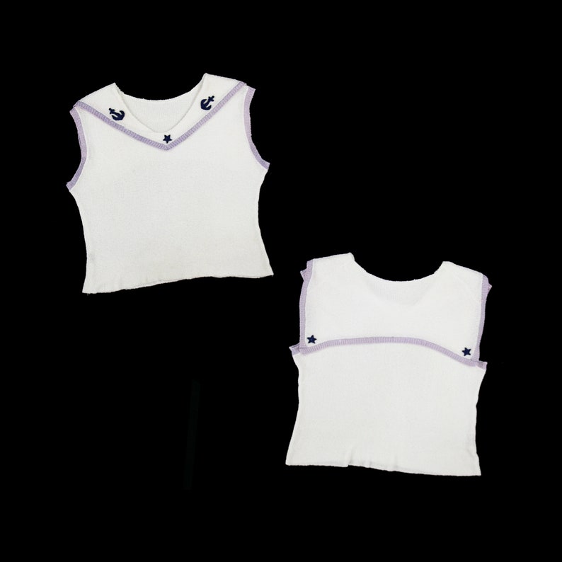May include: White sleeveless top with a purple trim and blue embroidered stars and anchors.