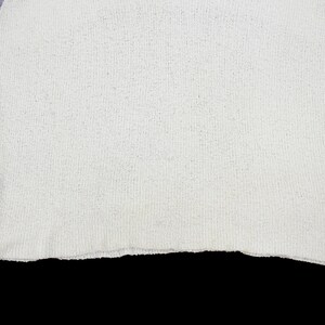 May include: White sleeveless shirt with a purple trim around the neckline and armholes.