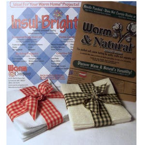 May include: Stacks of white fabric squares tied with red and white checkered ribbon and a brown and black checkered ribbon. A cardboard box with the text "Warm & Natural" and "Needled Cottons" is in the background. A flyer for "Insul-Bright" is also visible.