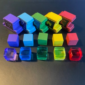 May include: A set of 10 colorful dice, including red, orange, yellow, green, blue, indigo, and violet. The dice are made of clear plastic and have a slightly frosted finish.