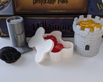 May include: A set of game pieces for a board game, including a gray tower with gold coins inside, a gray card holder, a white bone-shaped box with red tokens inside, and a black round token.