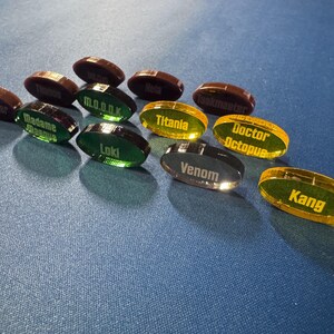 Marvel Villainous random tokens standing on their edge to show off their colors.