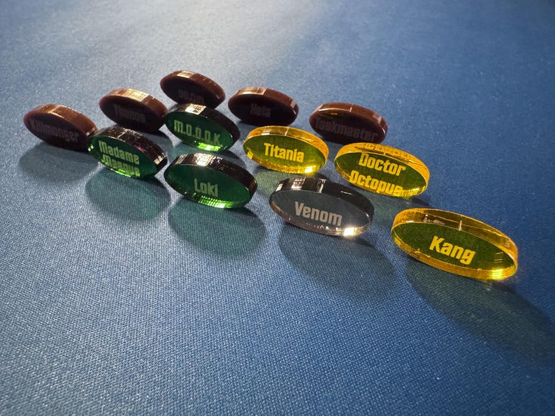 Marvel Villainous random tokens standing on their edge to show off their colors.