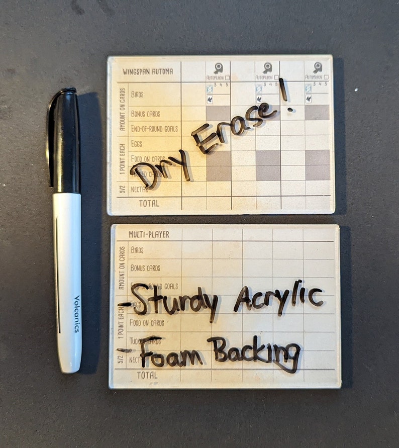 May include: Two white dry-erase scoreboards for the board game Wingspan. The top scoreboard has the text "Dry Erase!" written on it. The bottom scoreboard has the text "Sturdy Acrylic Foam Backing" written on it.