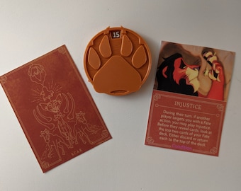 May include: An orange paw print token with the number 15, and two cards. One card features a stylized illustration of Scar, and the other card reads "INJUSTICE" with game instructions. The cards and token are on a white surface.