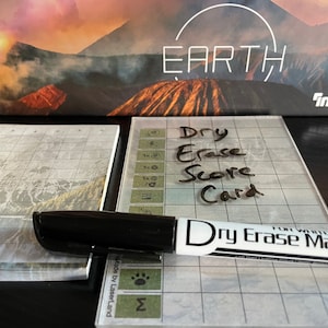 May include: A dry erase score card with a grid pattern and a dry erase marker. The card is labelled "Dry Erase Score Card".