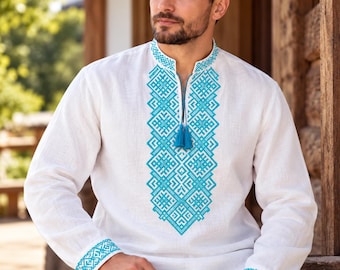 May include: A white long-sleeved shirt featuring a vibrant turquoise geometric embroidery pattern down the center chest and on the cuffs. The shirt has a mandarin collar with a small slit opening at the neck, finished with two turquoise tassels.
