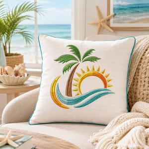 May include: A square white throw pillow featuring an embroidered design of a brown palm tree with green fronds, a yellow and orange sun, and blue waves. The pillow has a teal piped edge and a textured fabric finish, centered on a neutral chair.