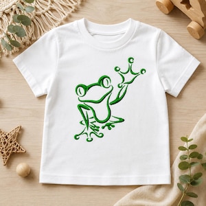 May include: A white short-sleeved t-shirt featuring a centered, embroidered green outline of a frog with its front left limb raised. The frog design is rendered in a bold, dark green thread, contrasting against the plain white fabric of the shirt.