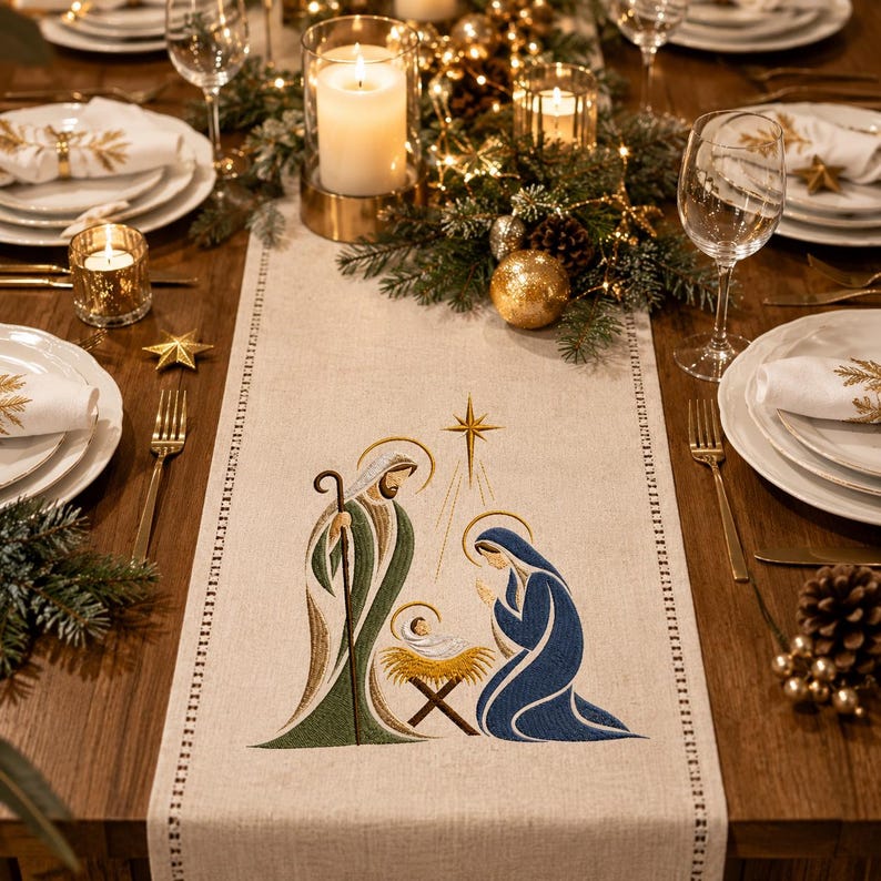 May include: A beige fabric table runner featuring an embroidered nativity scene with a central star, Joseph in green and gold robes, Mary in a blue robe, and a baby in a manger, set on a wooden dining table with white plates and glassware.