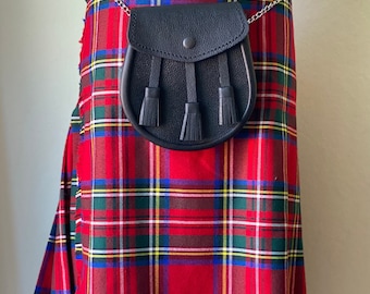 May include: A red, green, blue, and yellow plaid kilt with a black leather sporran. The sporran has three tassels and a silver chain. The kilt is wrapped around a form.