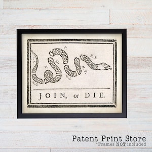 May include: Framed print featuring the iconic "Join, or Die" political cartoon. The black and white image depicts a segmented snake with the words "JOIN, or DIE" below. The print is in a black frame.