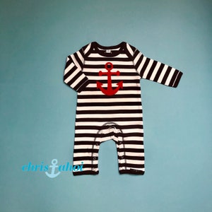 Könnte beinhalten: Ein langärmliger Baby-Strampler mit schwarzen und weißen Streifen und einem roten Anker auf der Vorderseite.
