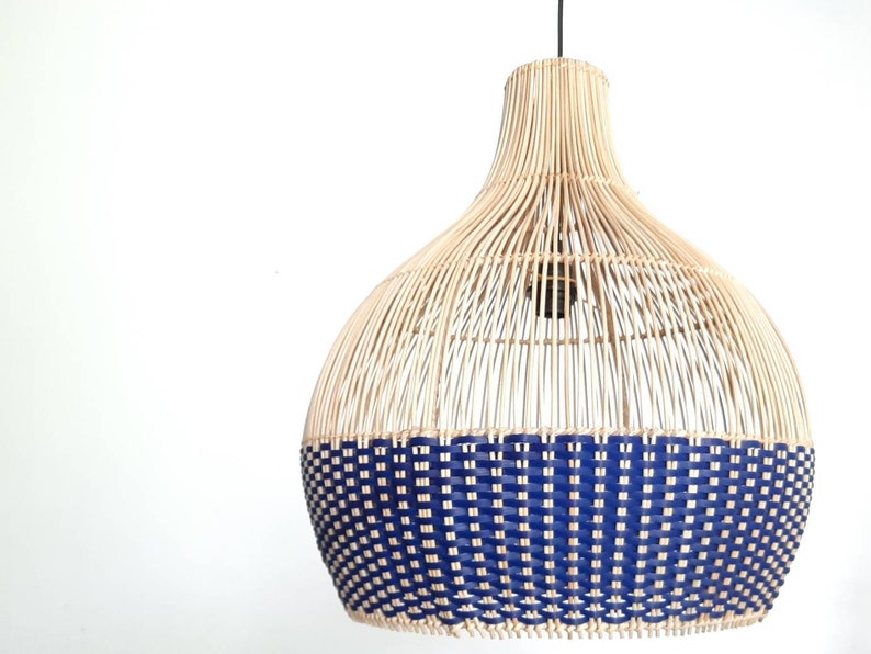 May include: A woven pendant light with a natural bamboo shade and a blue woven bottom. The light is hanging from a white ceiling.