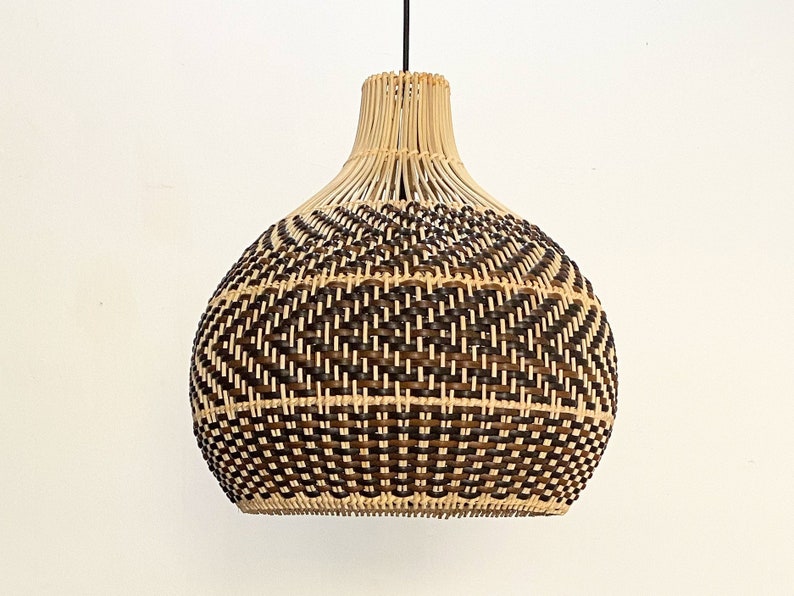 May include: A woven pendant light with a brown and natural color scheme. The light has a round, bulbous shape with a woven pattern.