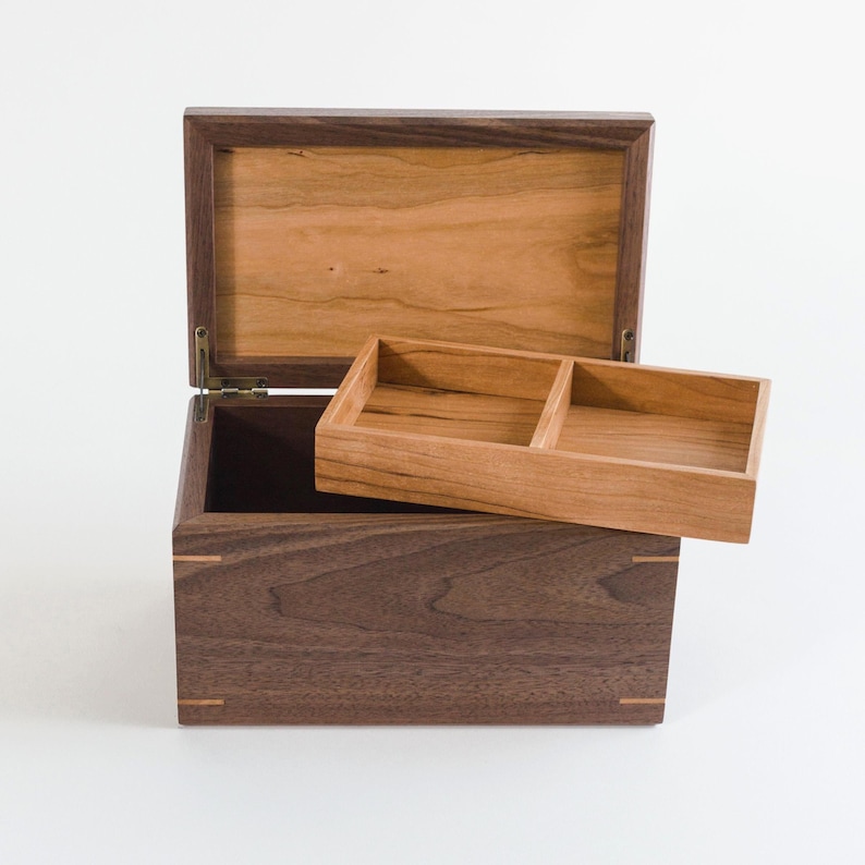 Handmade walnut keepsake box with removable cherry tray and cherry lid panel, showcasing fine craftsmanship and two-compartment organizer, ideal for memory storage or personalized gifting.