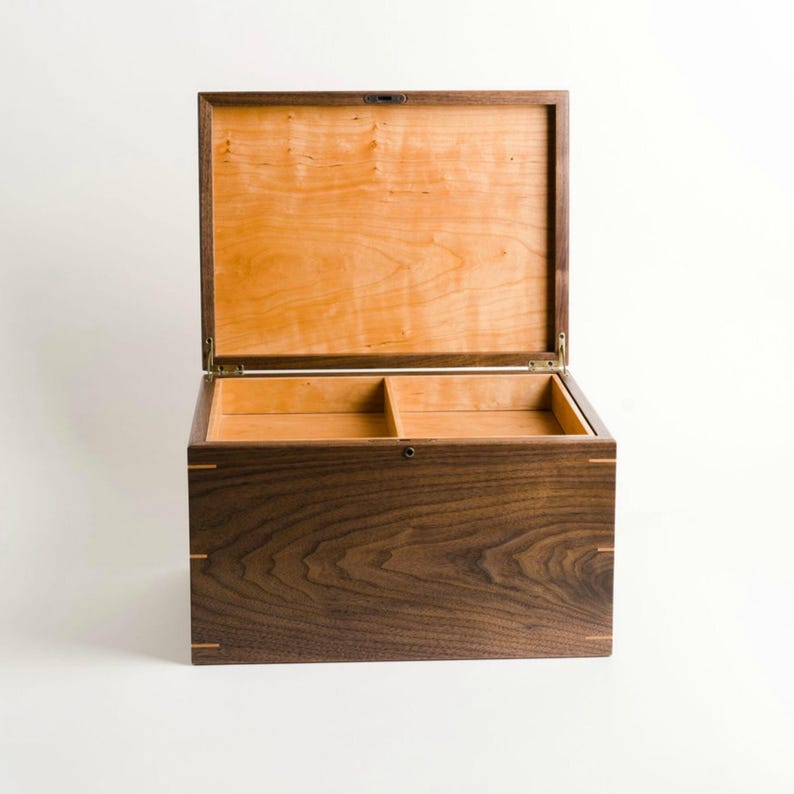 Handcrafted walnut keepsake box with open lid and two-compartment cherry interior removable tray, showing antique brass hinges and clean joinery.