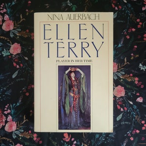 May include: A book titled "Ellen Terry: Player in Her Time" by Nina Auerbach. The cover features a black and white portrait of Ellen Terry in a long, flowing gown.