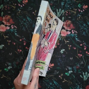 K&ouml;nnte beinhalten: Ein Taschenbuch mit dem Titel "The Black Book" von Laurence Durrell. Der Umschlag zeigt eine farbenfrohe Illustration einer Gruppe von Menschen.