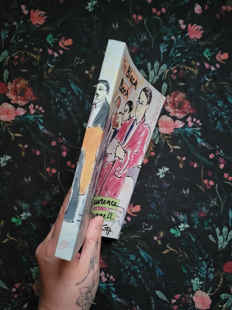 K&ouml;nnte beinhalten: Ein Taschenbuch mit dem Titel "The Black Book" von Laurence Durrell. Der Umschlag zeigt eine farbenfrohe Illustration einer Gruppe von Menschen.