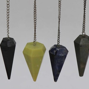May include: A set of 10 crystal pendulums with silver chains. The pendulums are made of various types of crystals, including green, red, black, and blue.