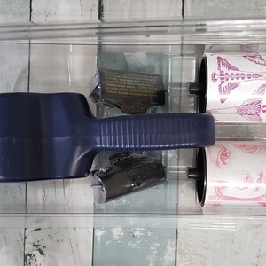 May include: A blue lint roller with two replacement rollers. The replacement rollers have pink and white designs.