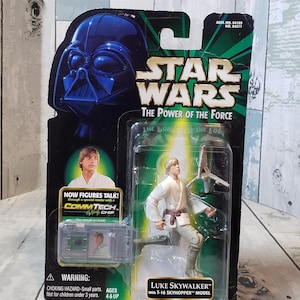 Könnte beinhalten: Star Wars Actionfigur von Luke Skywalker mit einem T-16 Skyhopper Modell, verpackt in einer transparenten Kunststoffhülle. Die Verpackung zeigt Darth Vaders Helm, das Star Wars Logo und den Text "The Power of the Force". Enthält einen CommTech-Chip.
