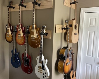 May include: A wall mounted guitar rack with eight guitars, including electric and acoustic guitars. The rack is made of wood and has a natural finish. The guitars are all different colors and styles.