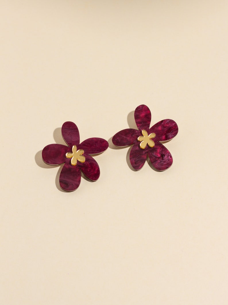 A pair of plum purple acrylic statement flowers earrings.