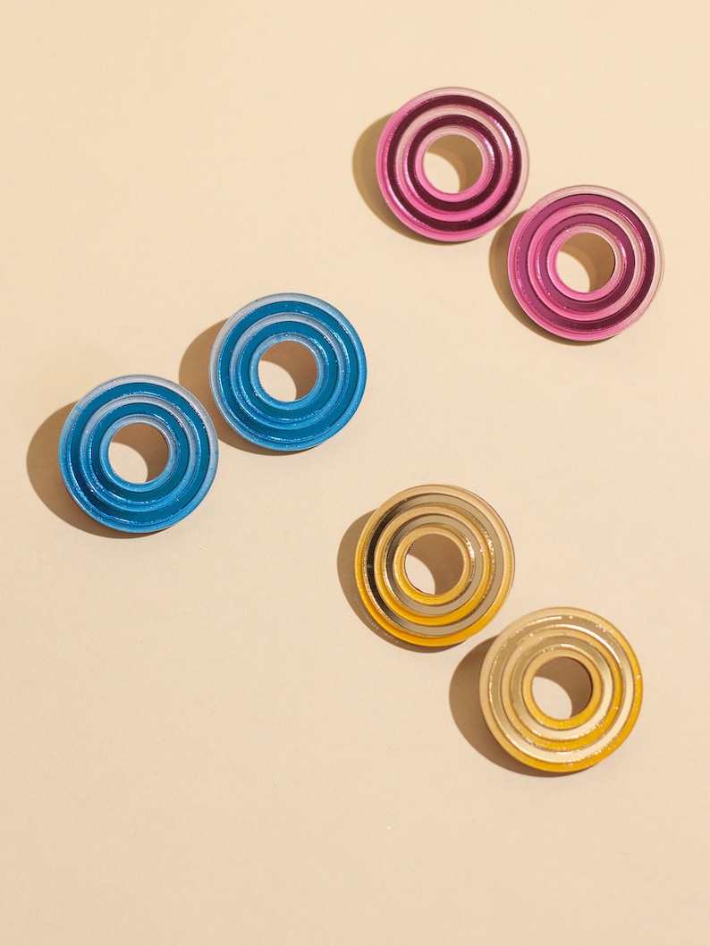A group photo of wearing  circular multicolored statement stud earrings.