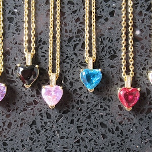 Può includere: Sei collane d'oro con ciondoli a forma di cuore. I ciondoli sono incastonati con pietre preziose di diversi colori: rosa, blu, nero, rosso, bianco e trasparente.