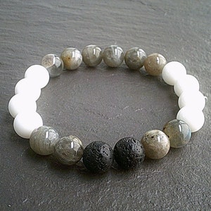 Op de afbeelding: Een armband gemaakt met witte, grijze en zwarte kralen. De armband heeft een mix van ronde en ovale kralen.