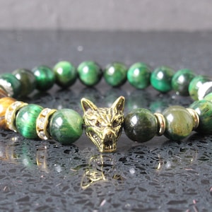 Può includere: Braccialetto con perline di occhio di tigre verde con un ciondolo a testa di lupo dorato. Il braccialetto ha alcune perline di cristallo trasparenti.