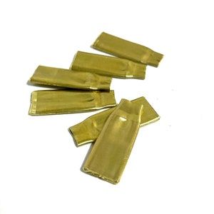 May include: Five gold-colored metal caps with a small hole in the center. The caps are arranged in a semi-circle on a white background.