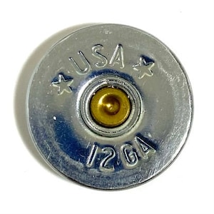 May include: A silver shotgun shell with a gold center and the text "USA 12 GA" printed on the side.