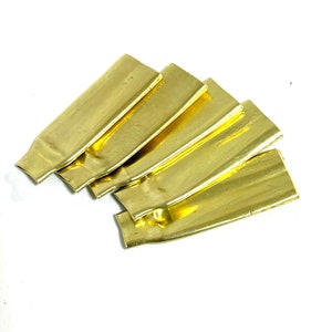 May include: Five gold-colored metal strips, arranged in a fan shape. The strips are smooth and shiny.