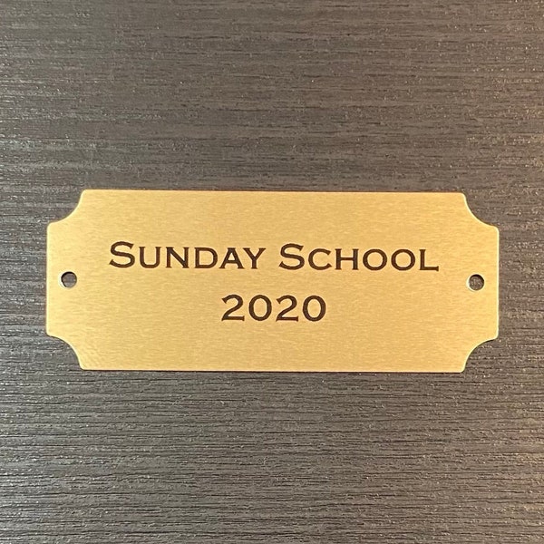 Custom Engraved 2 1/2" x 1" Gold Metal Plate w/ Notched Corners and Screws. Personalized for Memorials, Awards, Title Plates, and more.