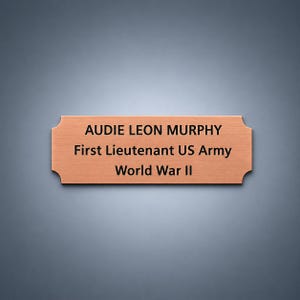 May include: A rectangular copper-toned metal plaque with notched corners featuring black engraved text that reads: AUDIE LEON MURPHY, First Lieutenant US Army, World War II. The plaque has a brushed finish and a clean, professional appearance.
