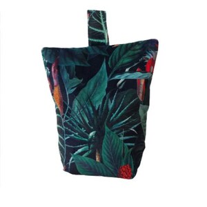 May include: A dark green and black doorstop with a tropical leaf print. The doorstop has a loop handle and red flowers.