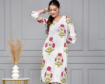 May include: White cotton kurta and palazzo pants set with a floral print in shades of pink and green. The set features lace trim on the sleeves and pants.