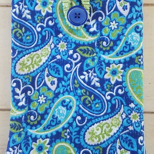 May include: A blue and green paisley patterned fabric pouch with a green button closure.