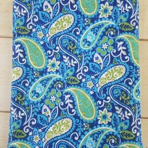 May include: A blue fabric with a paisley pattern in shades of green, white, and blue. The fabric has a subtle sheen and a textured surface.
