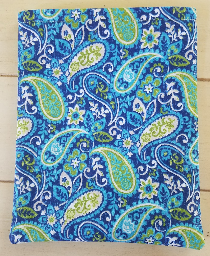 May include: A blue fabric with a paisley pattern in shades of green, white, and blue. The fabric has a subtle sheen and a textured surface.