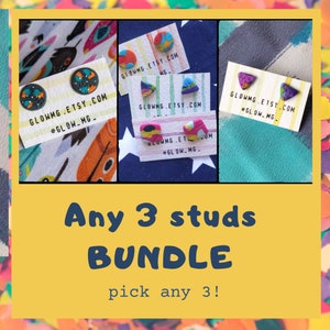 Può includere: Una collezione di orecchini a bottone colorati esposti su piccole carte. Gli orecchini presentano vari disegni, tra cui forme e motivi astratti. Il testo "Any 3 studs BUNDLE pick any 3!" è visualizzato sotto gli orecchini.