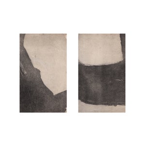 Puede incluir: Dos impresiones de arte abstracto con un esquema de color blanco y negro. Las impresiones presentan un fondo texturizado con una gran pincelada negra.