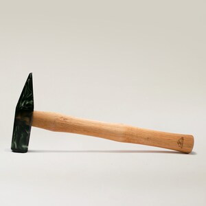 May include: A wooden-handled hammer with a black and green head. The hammer has a "GRIFFIN" logo on the handle.