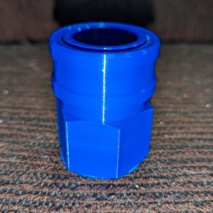 May include: A vibrant blue, 3D-printed connector with a hexagonal base and a cylindrical top. The connector has a ridged design and a hollow center. The object is likely used for plumbing or mechanical applications.