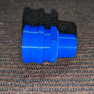 May include: A bright blue plastic fitting with a cylindrical shape. The fitting has a series of ridges and a hexagonal section in the middle. The object is likely a plumbing or mechanical component.