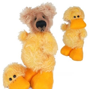 May include: A brown teddy bear wearing a yellow duck costume. The bear has black eyes and a black nose. The duck costume has a yellow beak and orange feet.